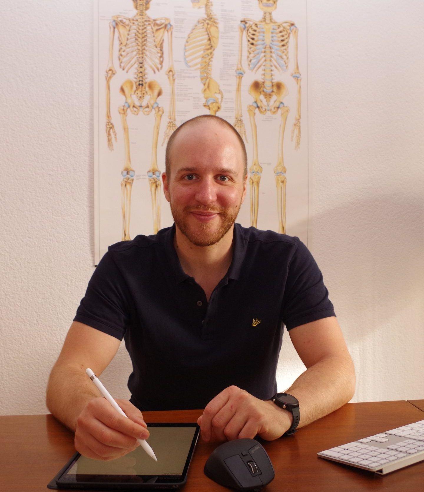 Etienne Ries sitzend in Praxis für Osteopathie Wiesbaden.